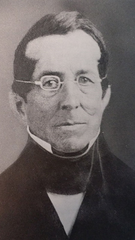 Black and white image of Thomas Hopkins Gallaudet facing the camera wearing glasses with a slight smirk on his face